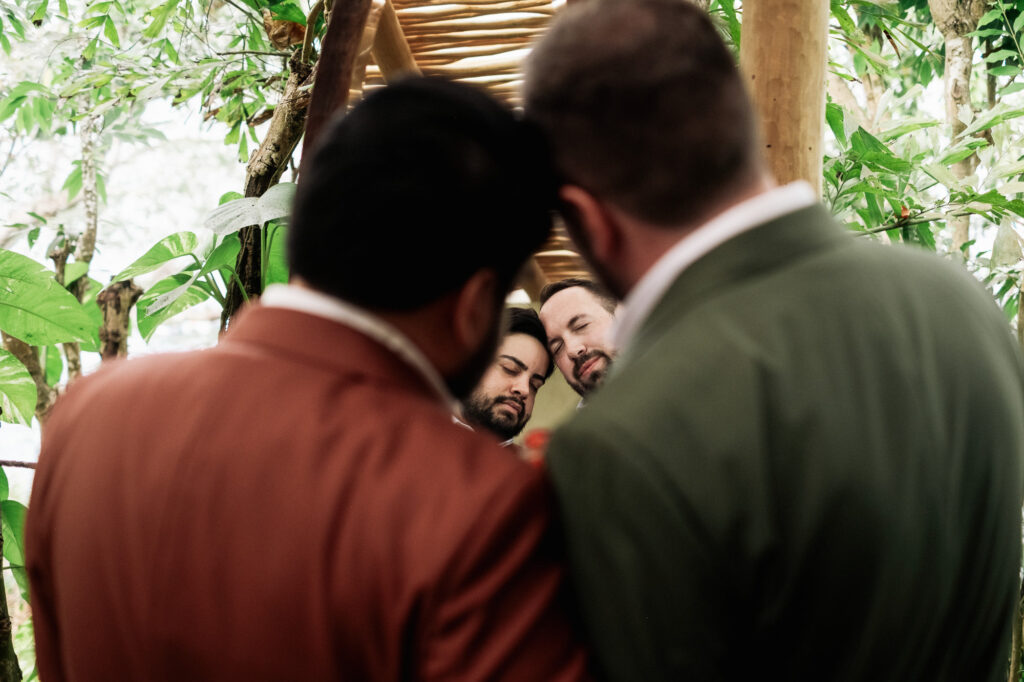 Two grooms share a tender moment during wedding ceremony at Las Caletas Puerto Vallarta