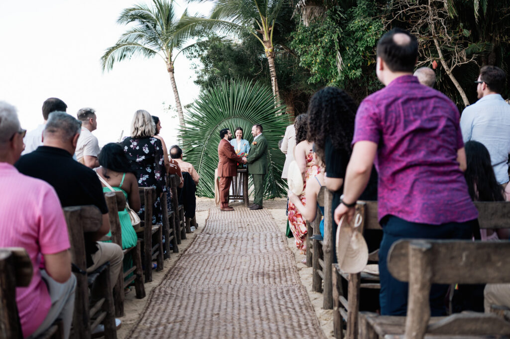 Same-sex wedding ceremony at Las Caletas Puerto Vallarta, two grooms holding hands at tropical altar