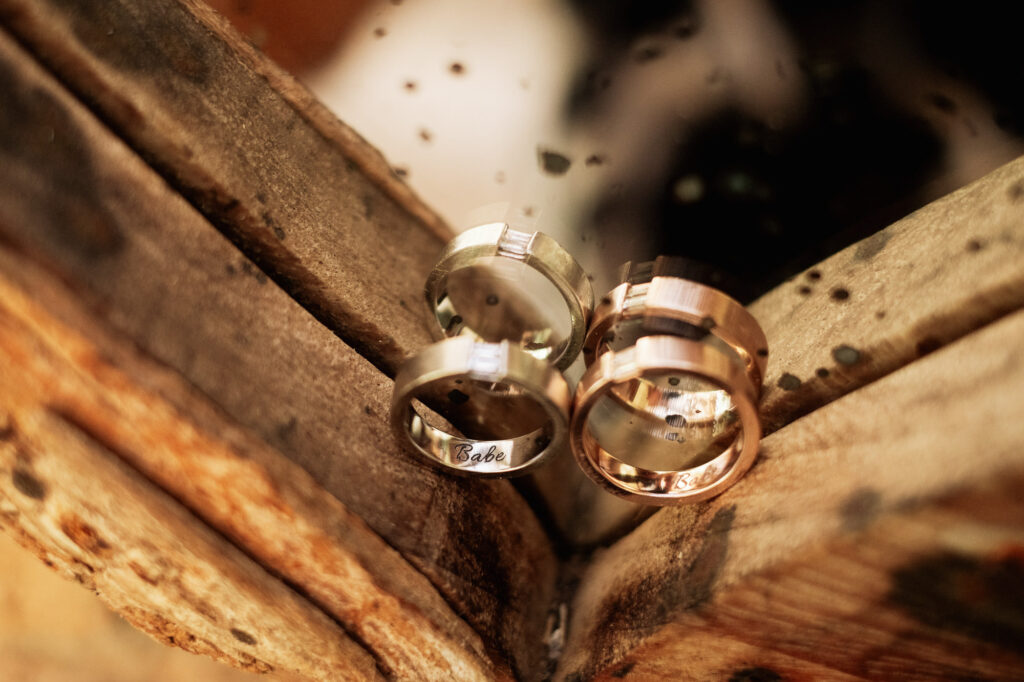Engraved wedding bands resting on rustic wood at Las Caletas, Puerto Vallarta wedding ceremony