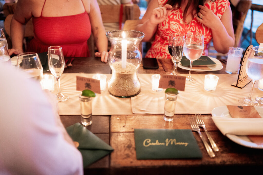 Wedding reception table detail at Las Caletas Puerto Vallarta with candle centerpiece and place card reading Carolina Murray