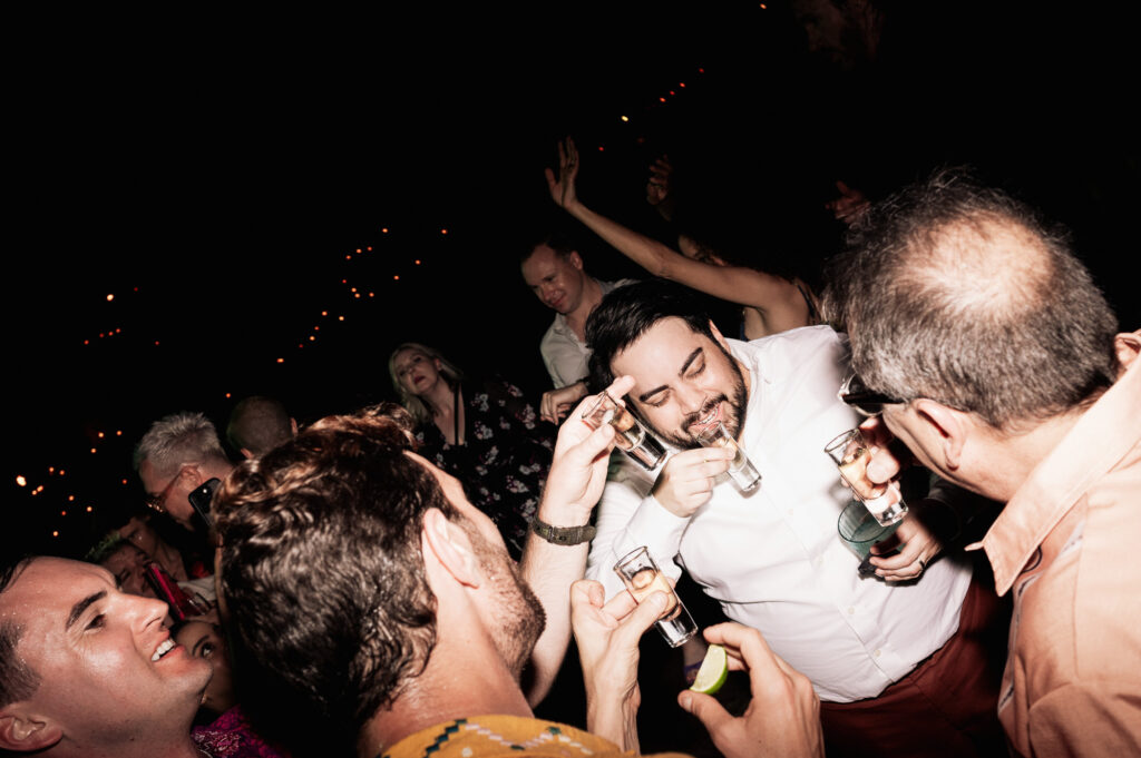 Guests taking tequila shots on the dance floor at a Las Caletas Puerto Vallarta wedding reception