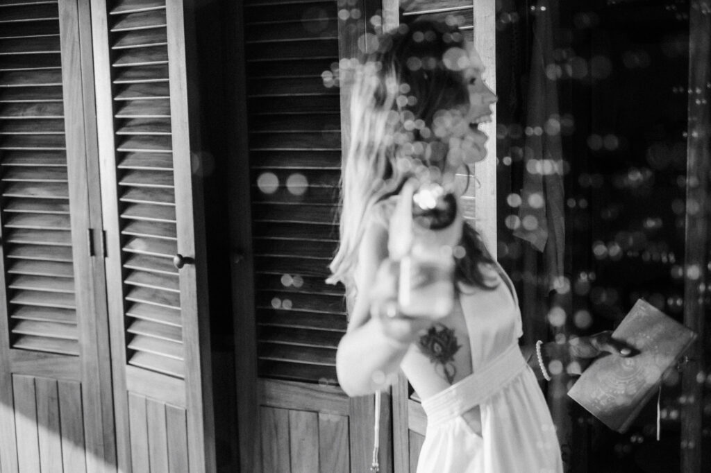 Bride laughing and holding champagne bottle at Villa del Sol Sayulita wedding reception, documentary film style