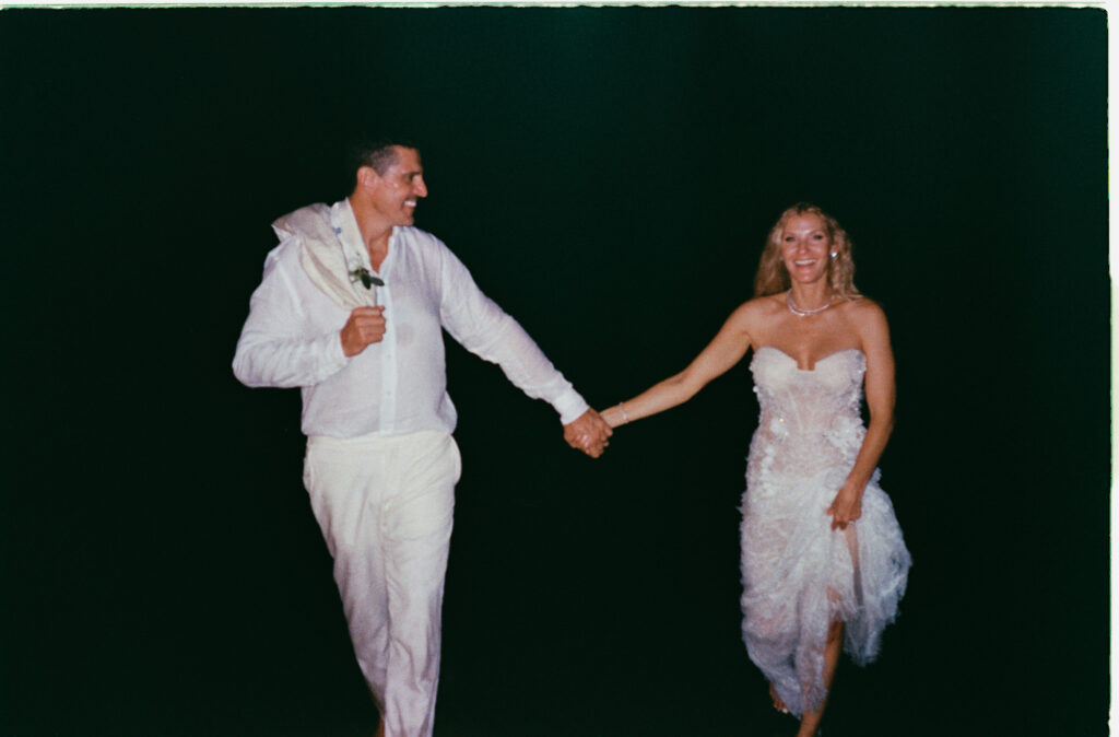 Bride and groom holding hands and laughing at night, One&Only Mandarina wedding reception, Mexico