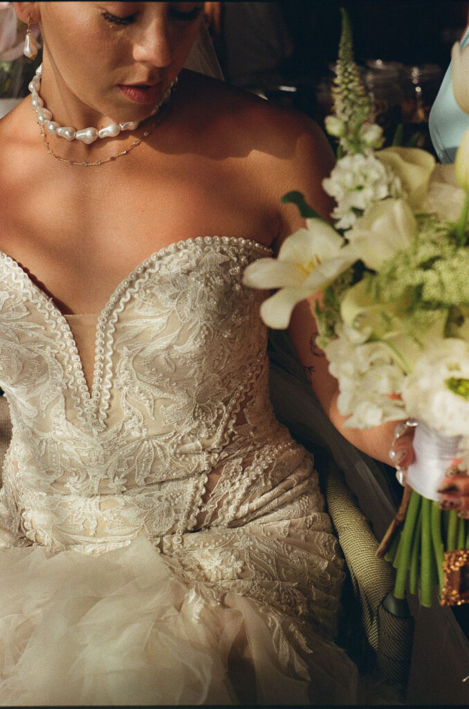 Bride in lace gown holding white bouquet at Hilton Riviera Vallarta wedding, film photography by Alex Obregón