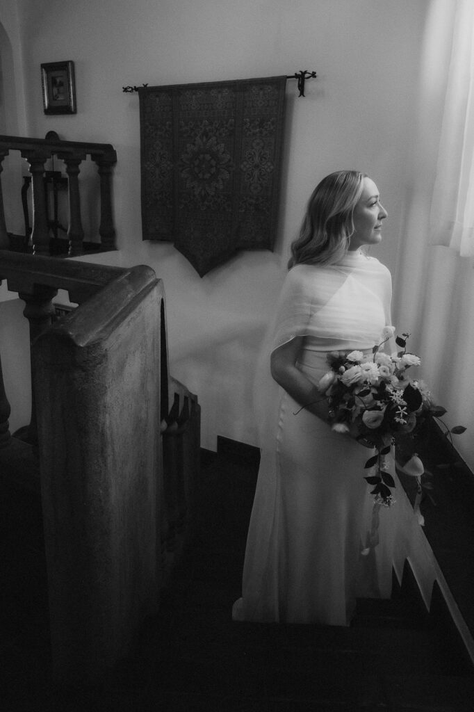 Bride in wedding gown holding bouquet on staircase, San Miguel de Allende wedding ceremony, film photography