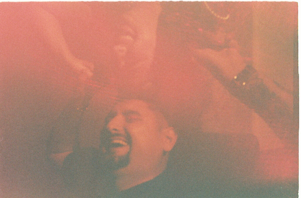 Groom laughing with eyes closed during wedding reception at Dreams Playa Mujeres, shot on 35mm film