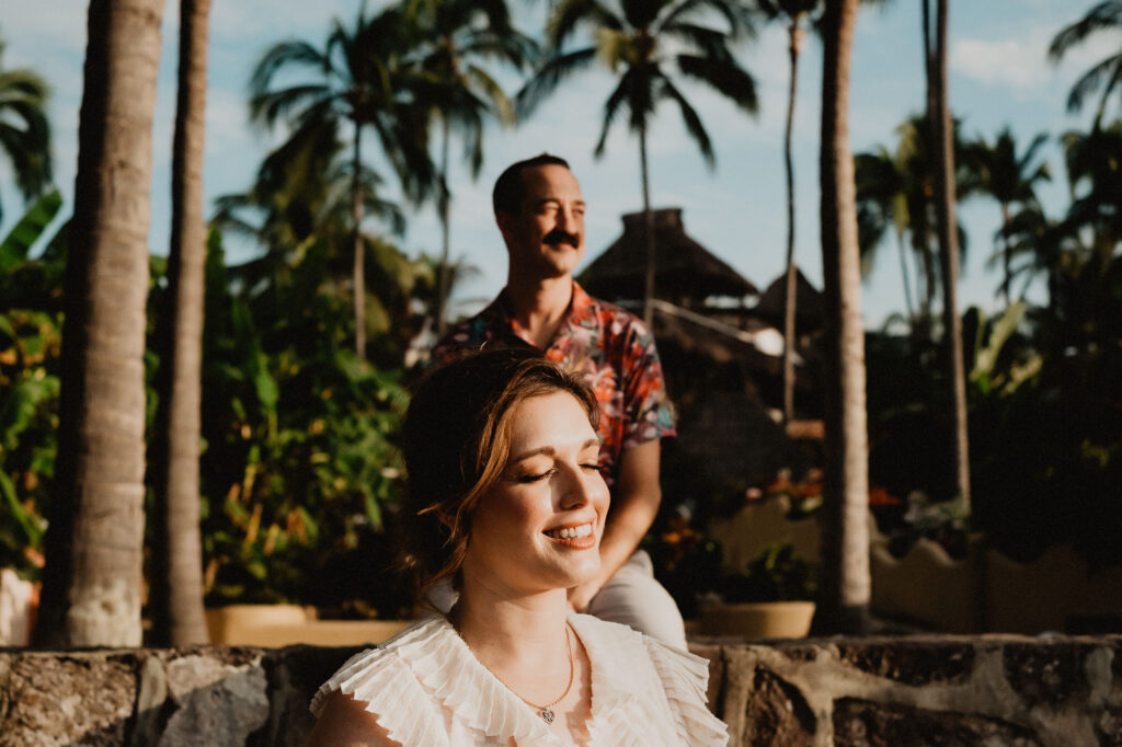 Couple during engagement session in Sayulita, Mexico, surrounded by palm trees at golden hour