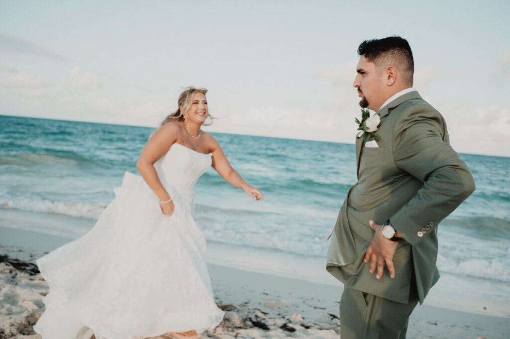 Bride running toward groom on beach at Dreams Playa Mujeres wedding, Cancun documentary style