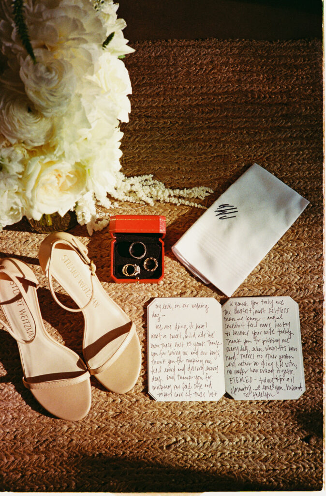 Elopement wedding flat lay with Stuart Weitzman heels, rings, handwritten vows, and bouquet at One&Only Mandarina