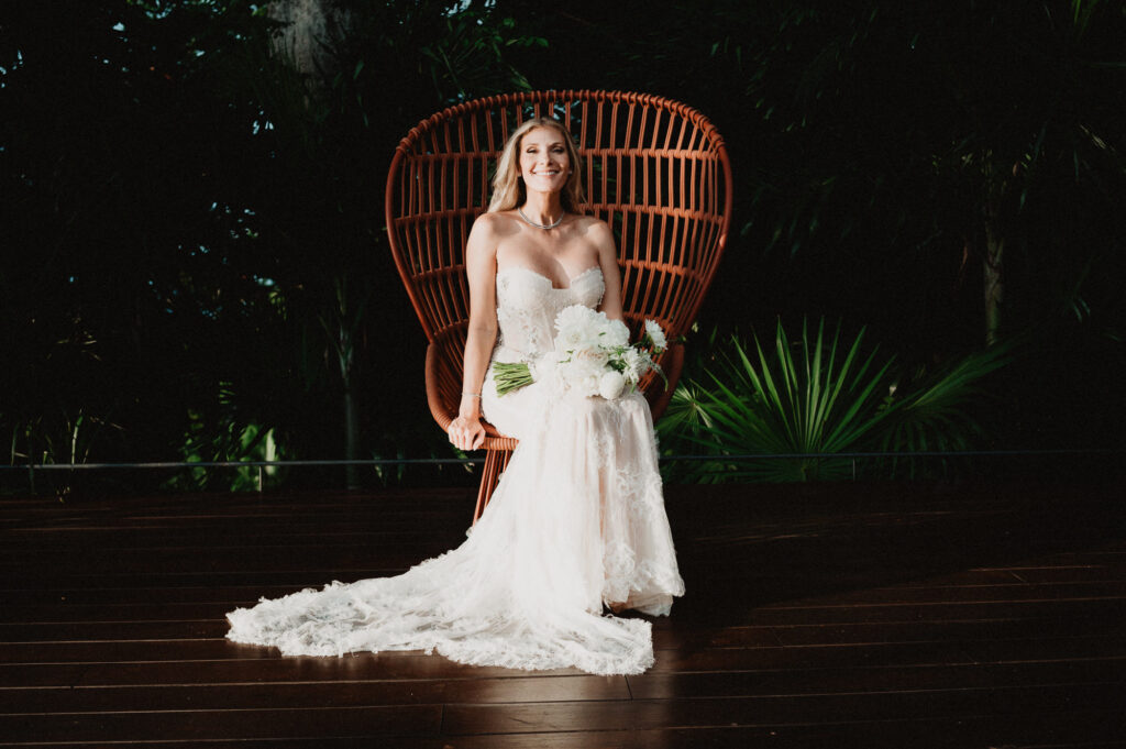 Bride in lace gown seated in rattan peacock chair at One&Only Mandarina, elopement portrait by Alex Obregón