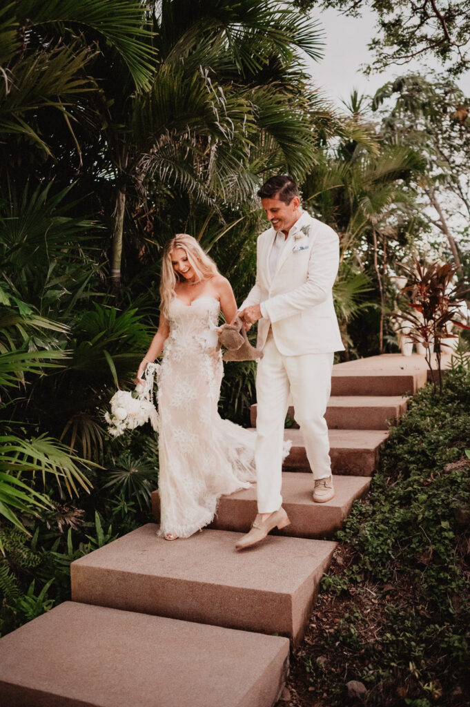 Bride and groom walking down tropical stone steps at One&Only Mandarina elopement, Mexico