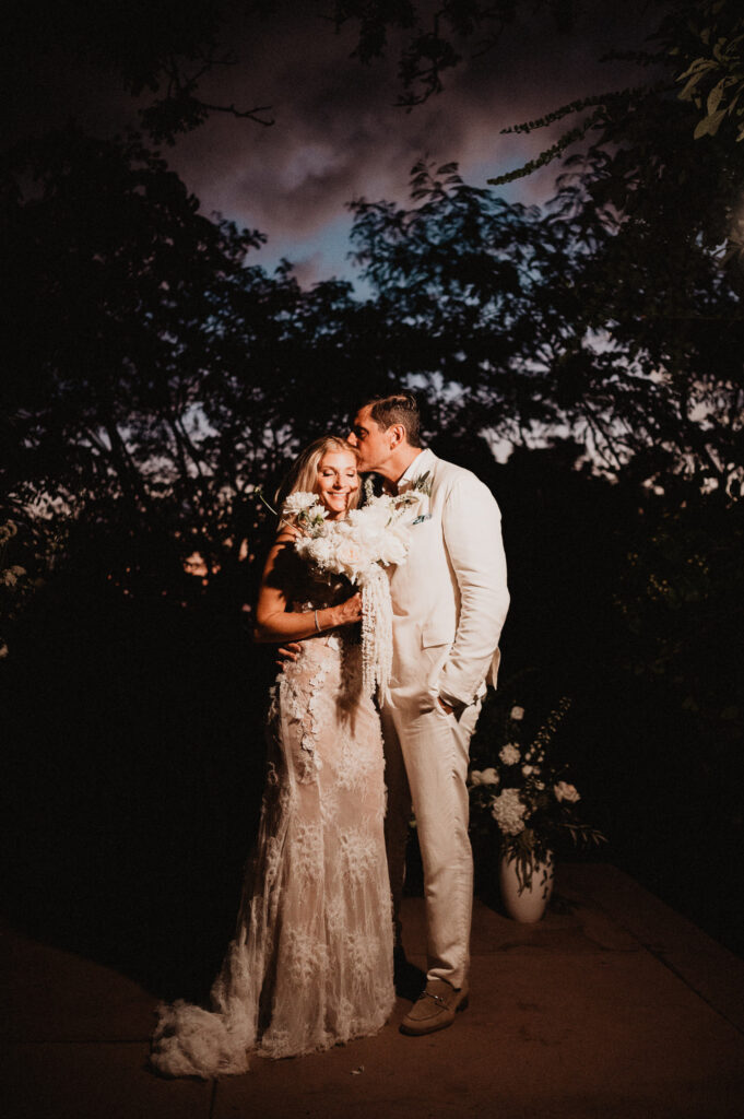 Bride and groom share a tender kiss at dusk during their elopement at One&Only Mandarina, Mexico