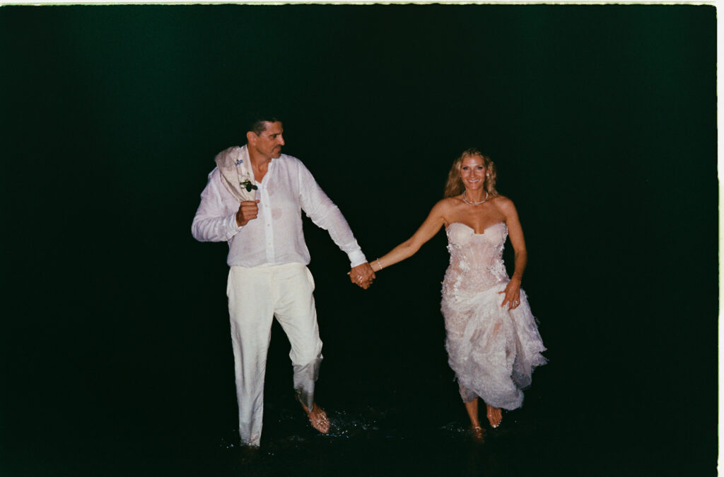 Couple wading into ocean at night during elopement at One&Only Mandarina, shot on 35mm film