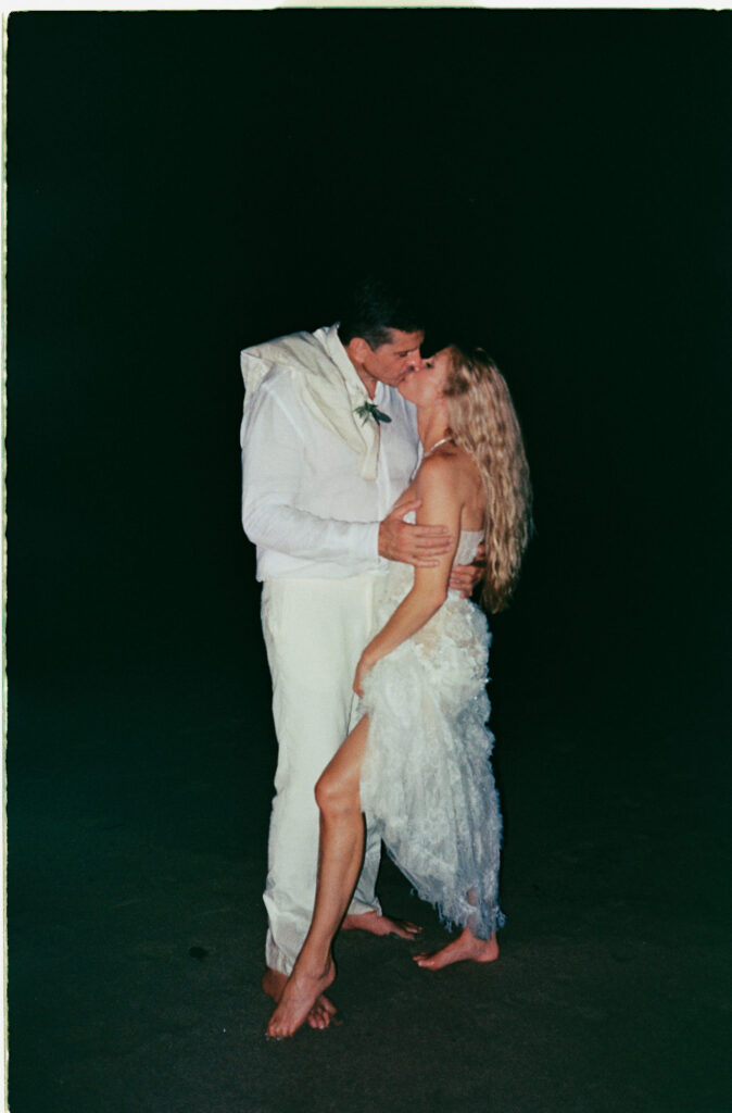 Couple sharing first kiss on beach at night, barefoot elopement at One&Only Mandarina, Mexico, shot on 35mm film