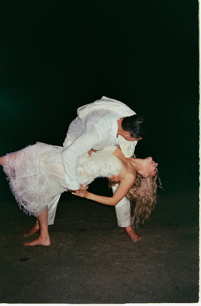 Couple sharing a romantic dip kiss on the beach at One&Only Mandarina elopement, shot on 35mm film