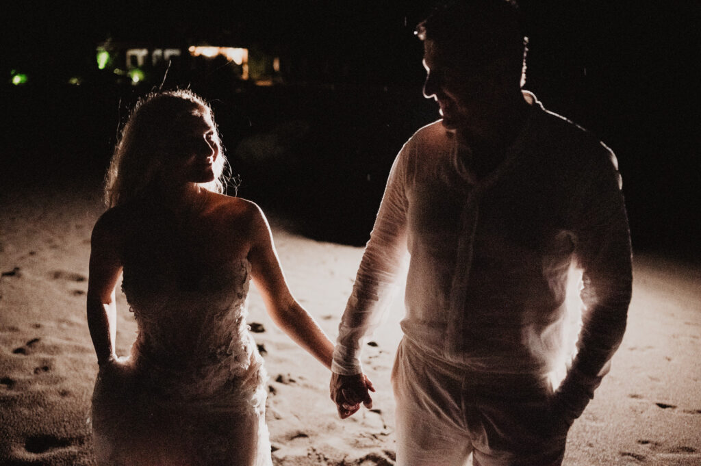 Bride and groom holding hands on beach at night, elopement at One&Only Mandarina, Mexico