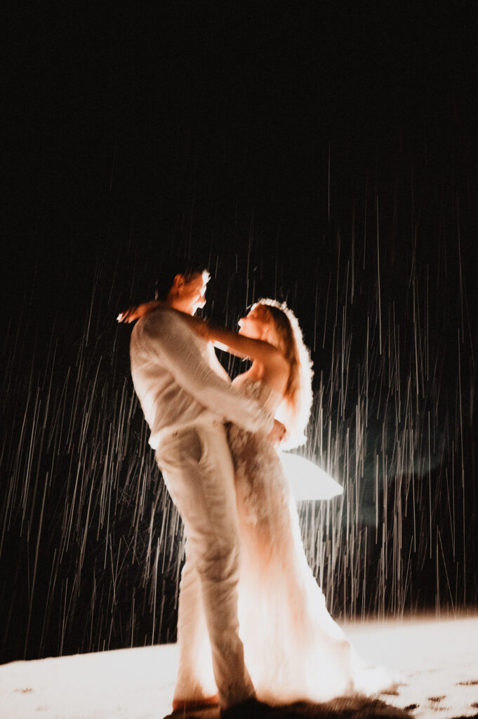 Bride and groom dancing in the rain at night, elopement wedding at One&Only Mandarina, Mexico