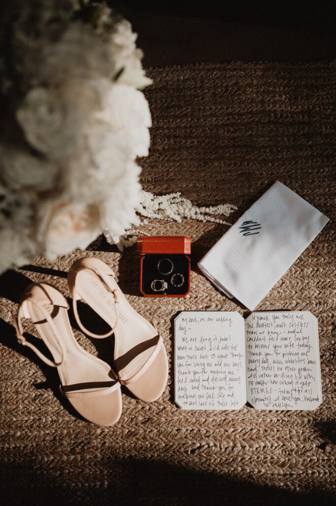 Elopement wedding flat lay with rings, vows letter, bridal heels, and bouquet at One&Only Mandarina