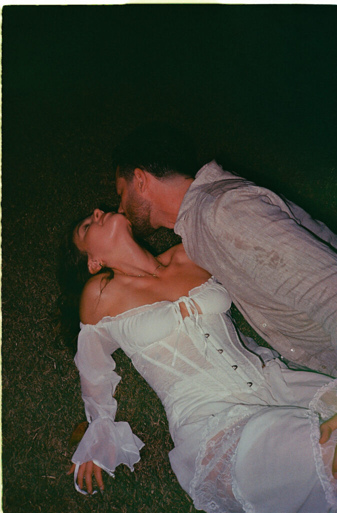 Couple sharing an intimate kiss at night on grass in Puerto Vallarta engagement session on film