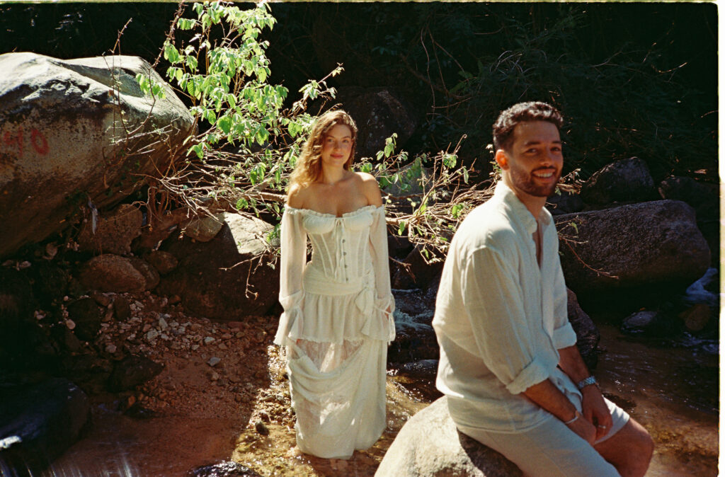 Couple in white during engagement session by a rocky stream in Puerto Vallarta, shot on 35mm film