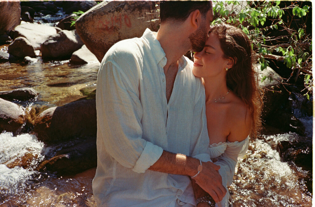 Couple embracing in a sunlit river, engagement session in Puerto Vallarta shot on 35mm film