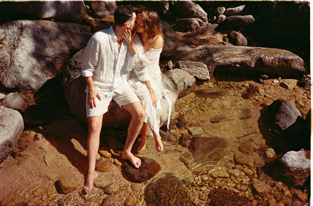 Couple kissing on rocky shore during engagement session in Puerto Vallarta, shot on 35mm film