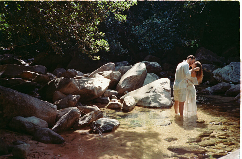 Couple kissing in a rocky river stream during engagement session in Puerto Vallarta, shot on 35mm film