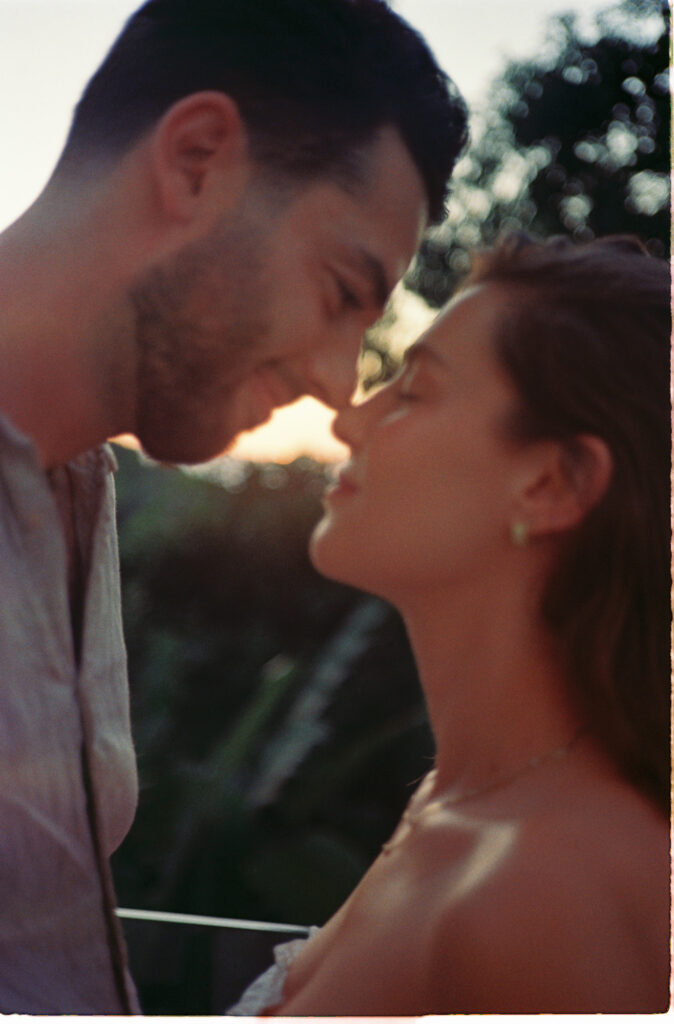 Couple sharing an intimate almost-kiss at golden hour, engagement session in Puerto Vallarta shot on 35mm film