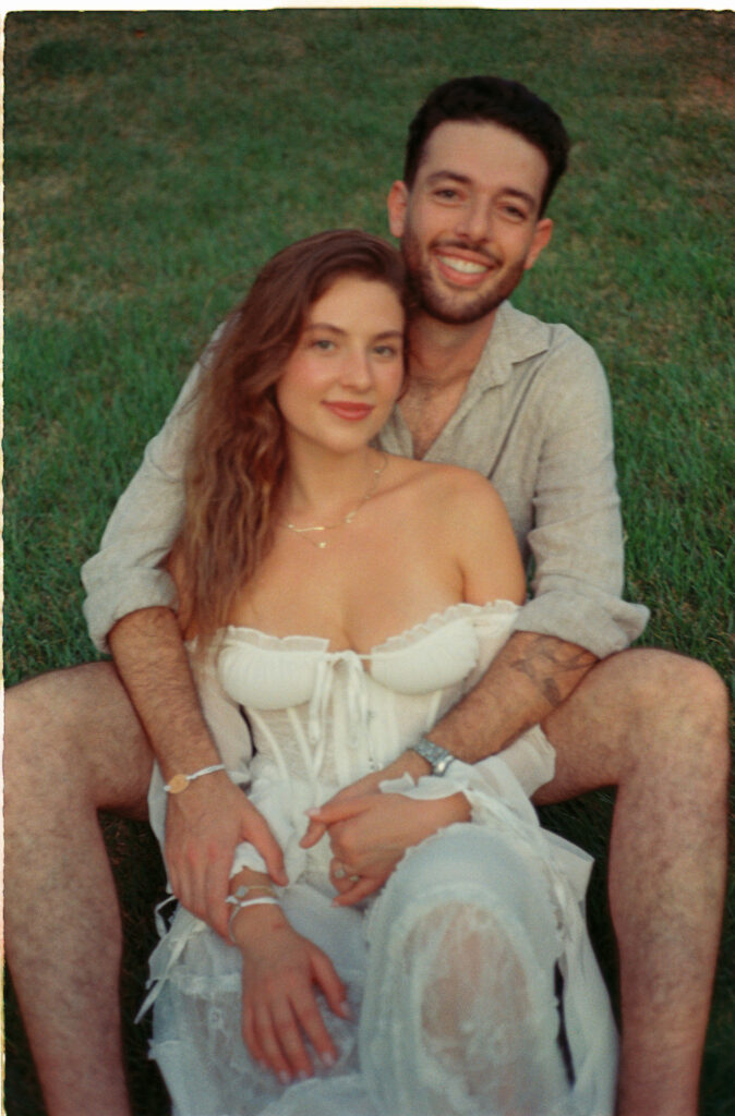 Couple sitting together on grass during engagement session in Puerto Vallarta, shot on 35mm film