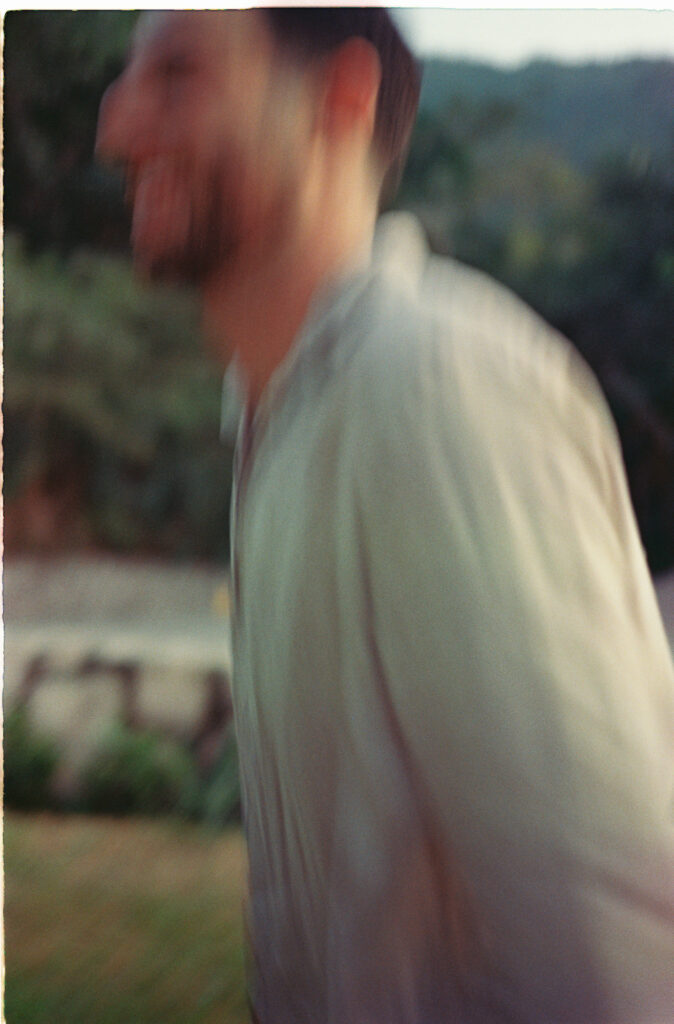 Blurred motion portrait of man laughing outdoors, engagement session in Puerto Vallarta by film photographer