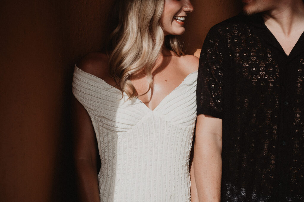 Bride smiling in white off-shoulder dress beside partner at Casa Cosmos, Puerto Vallarta engagement session