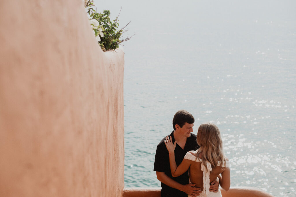 Couple embracing at Casa Cosmos Puerto Vallarta with turquoise ocean backdrop, engagement session