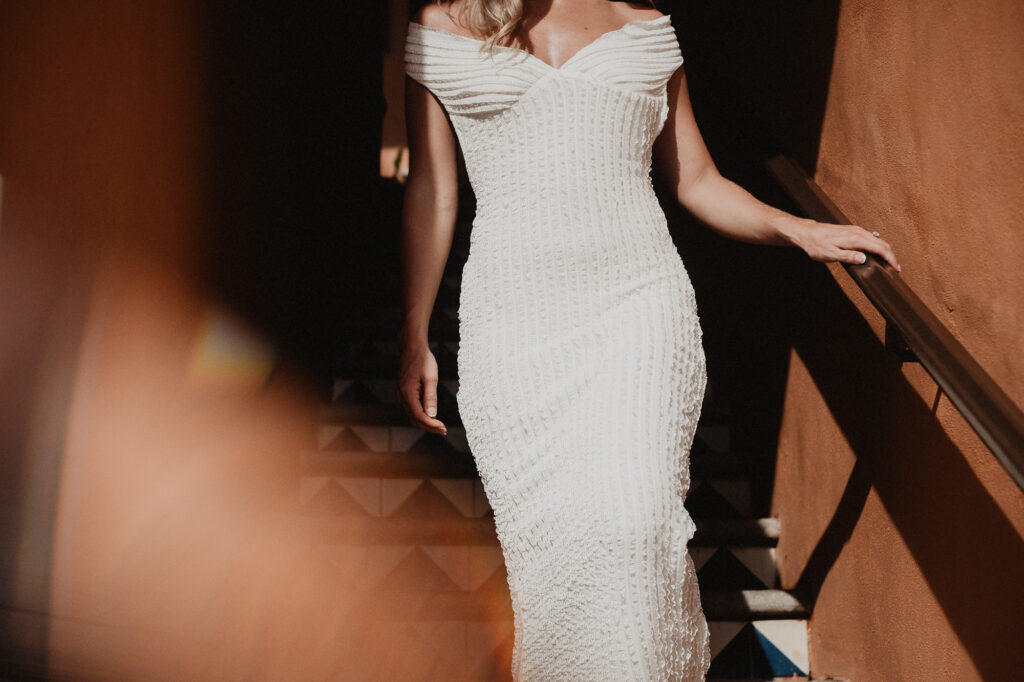 Bride in off-shoulder fitted lace gown on staircase at Casa Cosmos, Puerto Vallarta wedding portrait