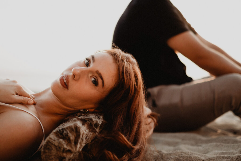 Woman lying on sand at golden hour, Puerto Vallarta engagement session by photographer Alex Obregón