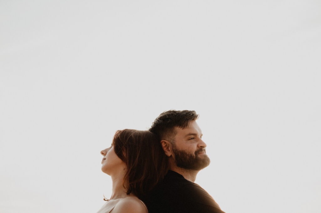 Couple back to back at golden hour, engagement session in Puerto Vallarta by pre wedding photographer Alex Obregón