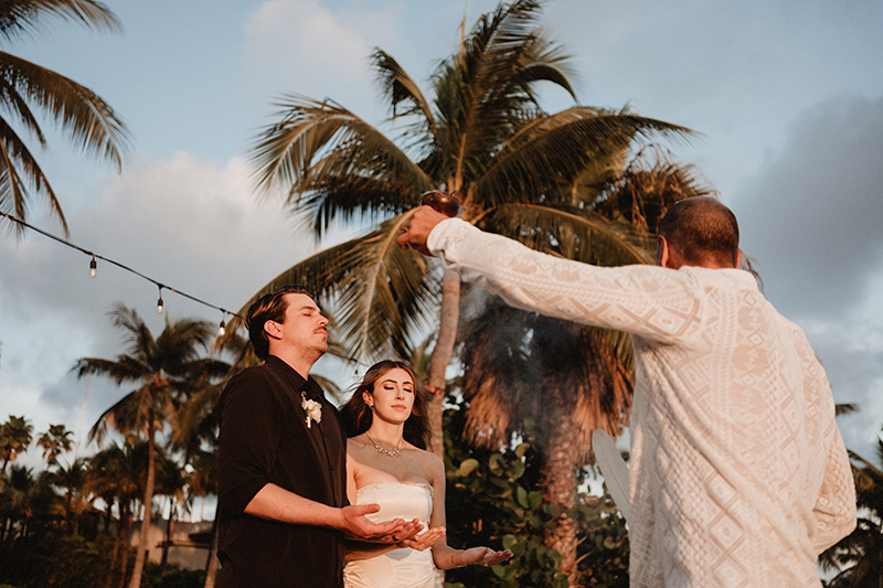 Wedding ceremony blessing at St Regis Punta Mita, officiant performing ritual over couple at sunset
