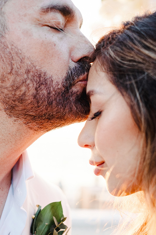 Groom kissing bride's forehead at wedding ceremony in Puerto Vallarta, Mexico, documentary style
