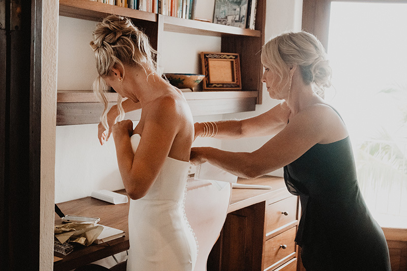 Bride getting dressed at Casa Cosmos, Puerto Vallarta wedding, bridesmaid fastening white gown