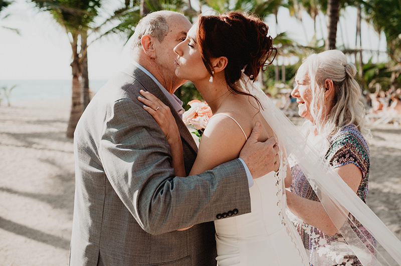 Bride kissing her father's cheek at beach wedding ceremony, Riu Vallarta, Puerto Vallarta