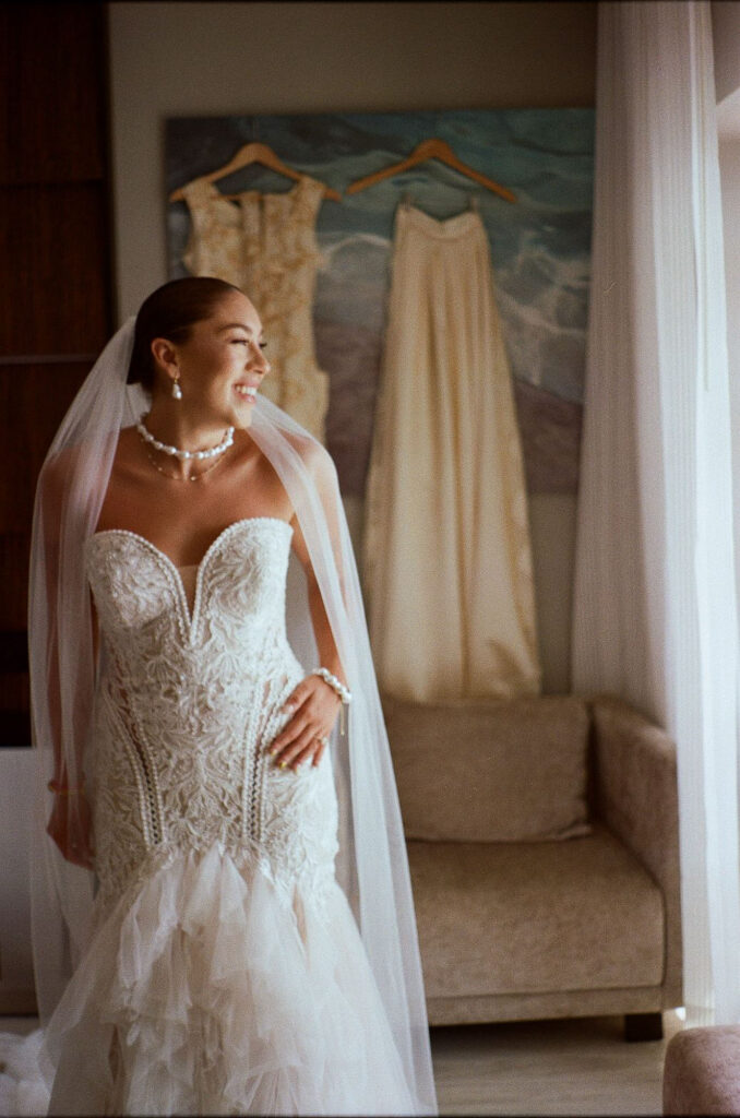Bride in lace mermaid gown and veil smiling before wedding ceremony at Hilton Puerto Vallarta