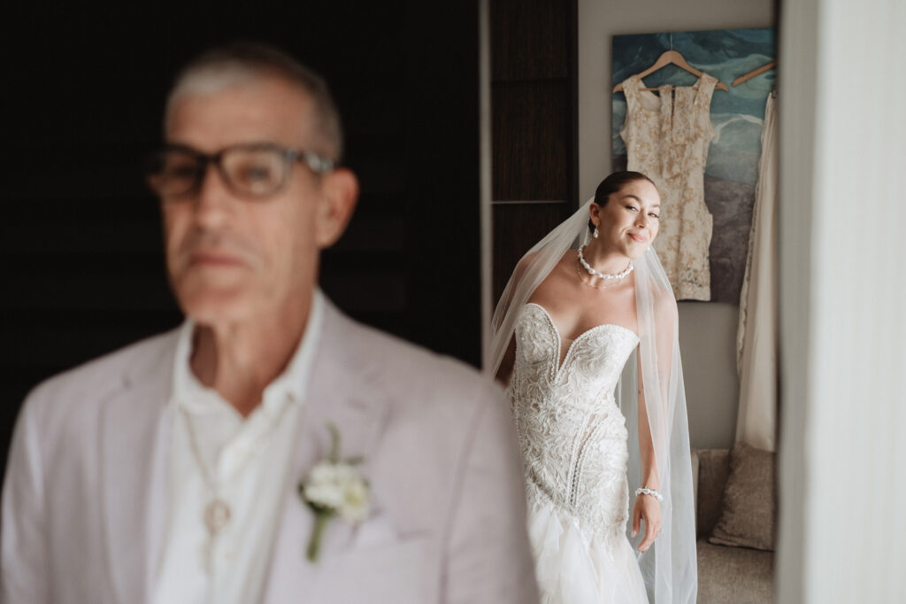Bride in lace gown and veil shares a first look moment with her father at Hilton Puerto Vallarta wedding