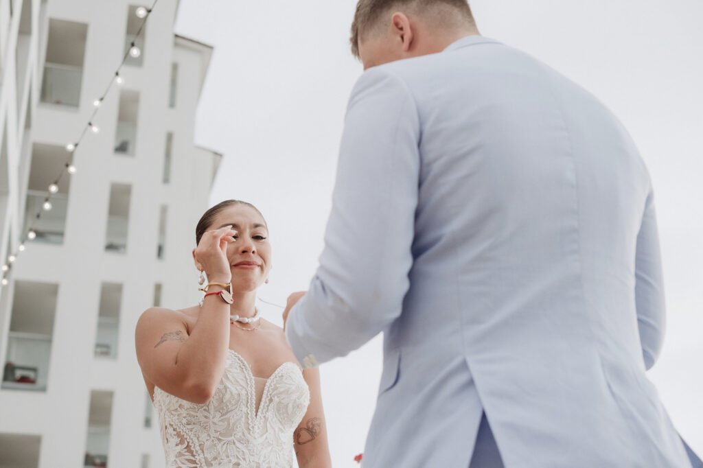 Bride wiping tears during wedding vows at Hilton Puerto Vallarta, documentary ceremony photography