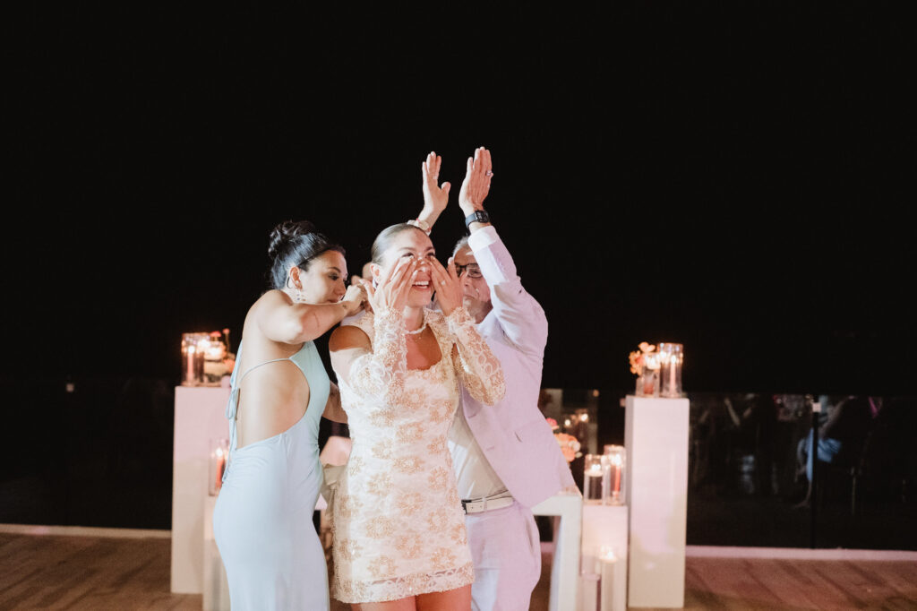 Bride overcome with emotion at Hilton Puerto Vallarta wedding reception, comforted by friends at night