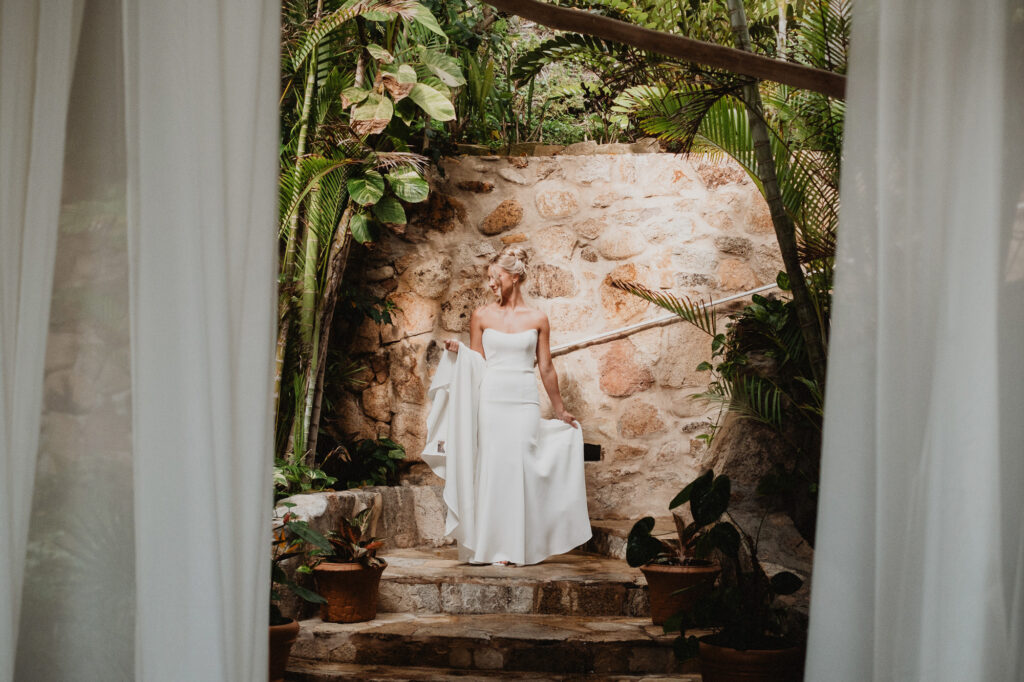 Bride in strapless white gown standing on stone steps at Casa Cosmos, Puerto Vallarta wedding