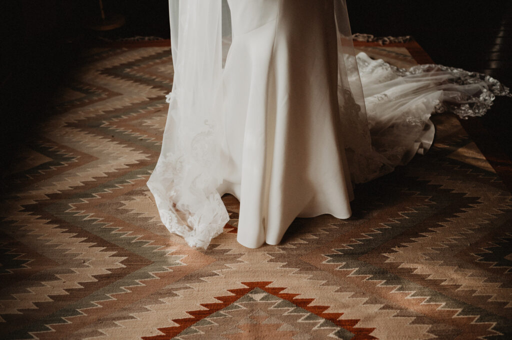 Bride in white gown and lace veil standing on kilim rug at Casa Cosmos, Puerto Vallarta wedding