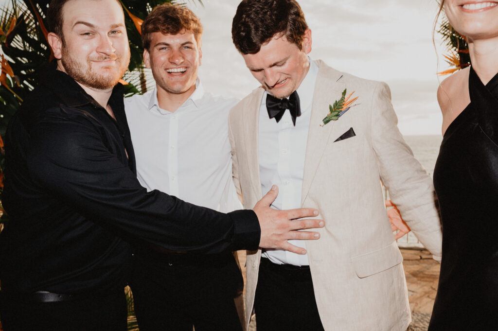 Groom laughing with groomsmen at Casa Cosmos wedding reception, Puerto Vallarta, photo by Alex Obregón