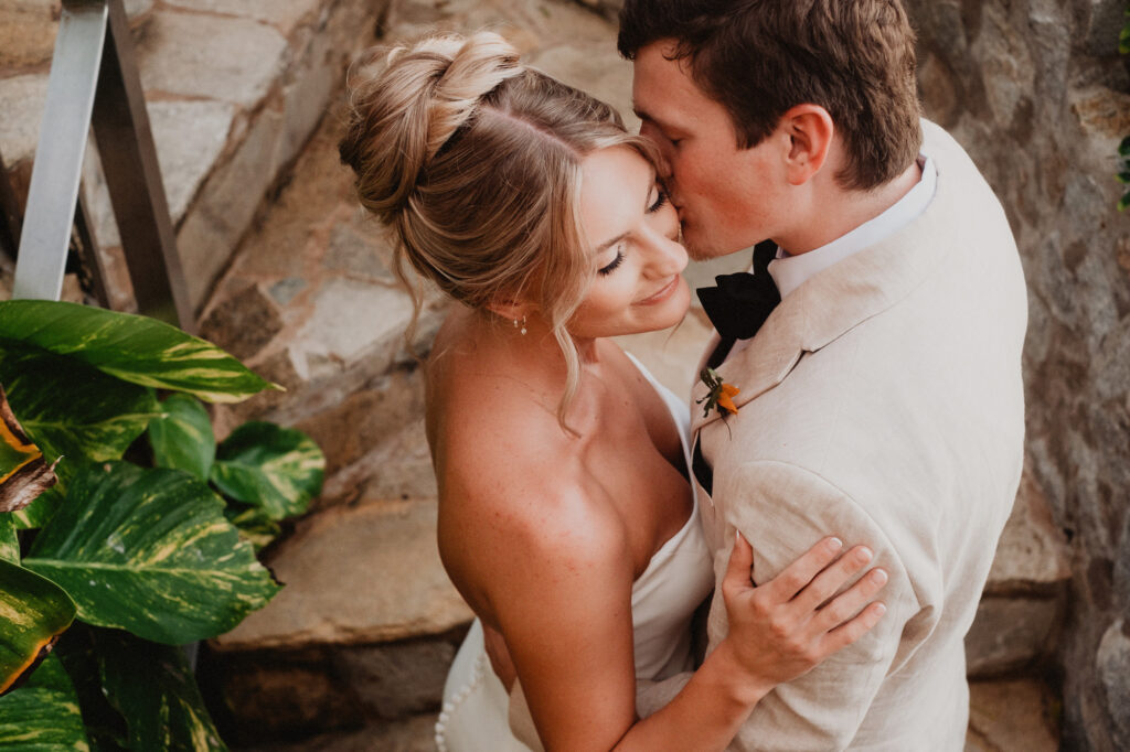 Bride and groom share tender moment at Casa Cosmos wedding, Puerto Vallarta, surrounded by tropical greenery