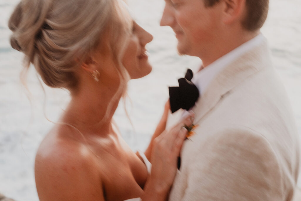 Bride adjusting groom's bow tie at Casa Cosmos, Puerto Vallarta wedding ceremony near the ocean