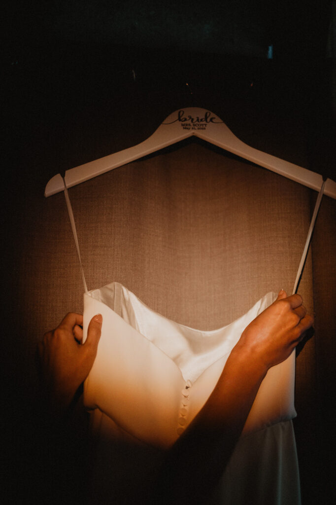 Bride holding white wedding dress on custom hanger at Casa Cosmos, Puerto Vallarta wedding