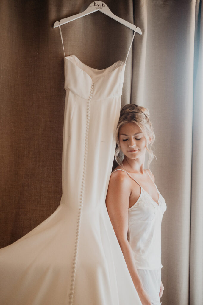 Bride gazing at her wedding gown on a custom hanger at Casa Cosmos, Puerto Vallarta wedding